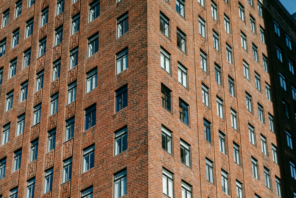 Close-up view of a red brick building facade emphasizing its structured windows and urban design.