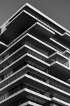 A striking black and white photo of a modern high-rise building with unique geometric designs.