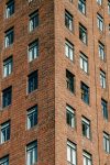 Close-up view of a red brick building facade emphasizing its structured windows and urban design.